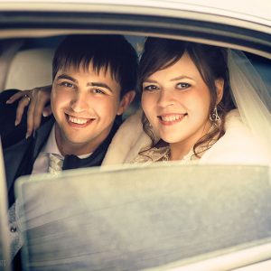 счастливая свадебная пара в лимузине