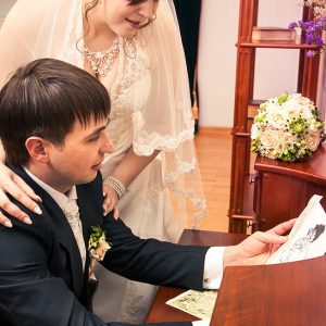 жених с невестой рассматривают картинку - свадебная фотография